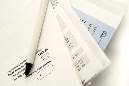 Stack of unpaid bills and invoices with a pen on top, representing legal billing, expenses, and financial management.